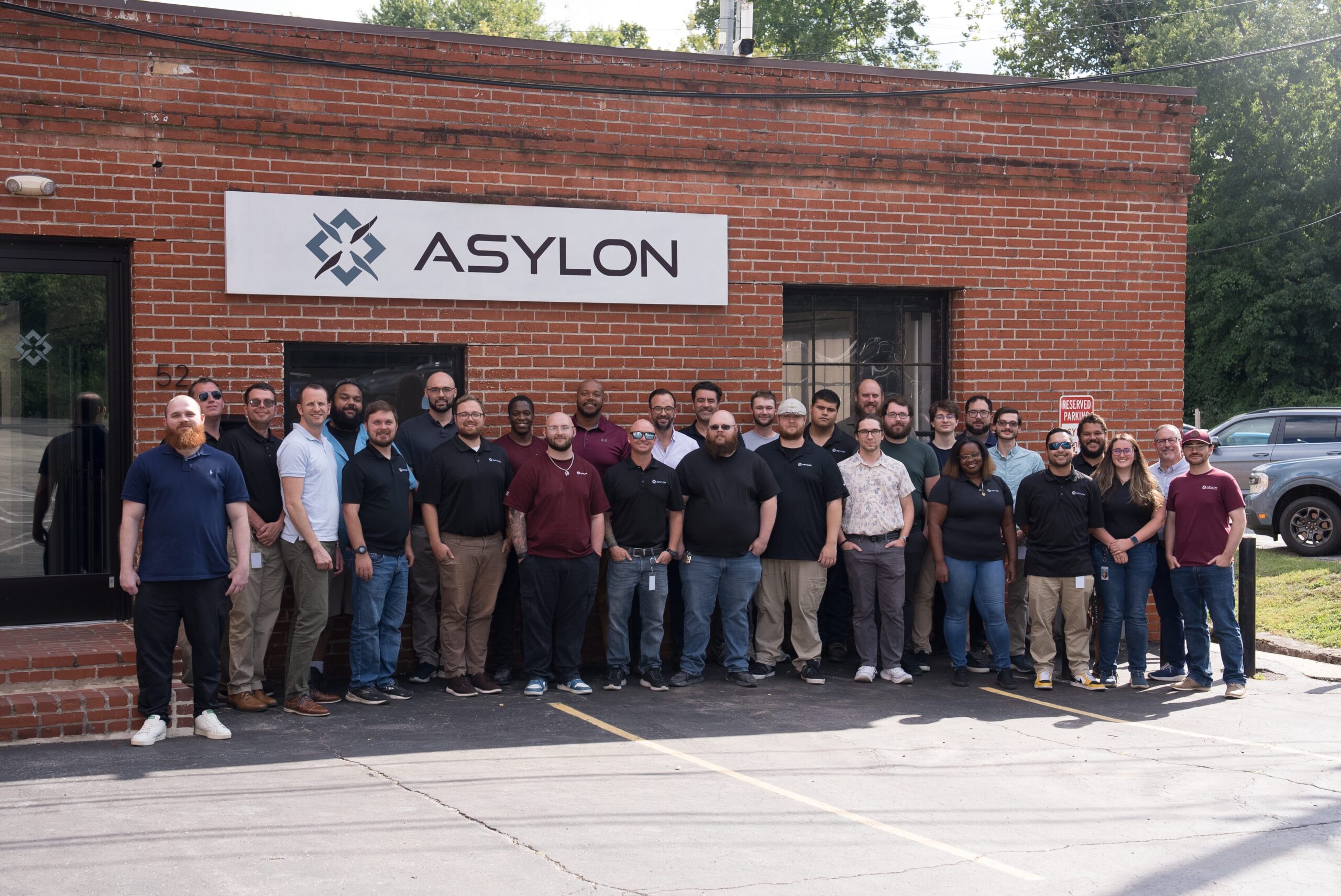Team members at Asylon gather for a group photo in front of the building