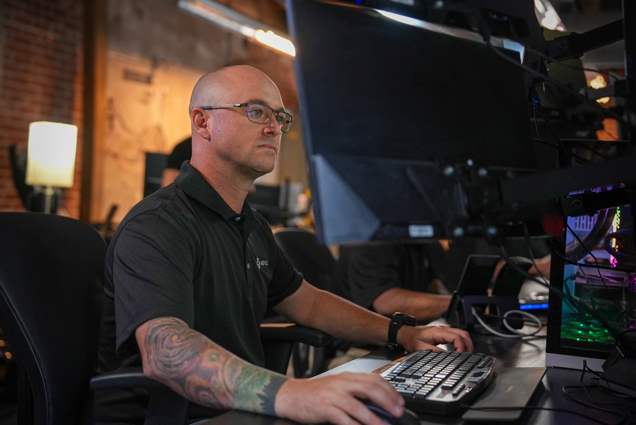 DroneDog operator sits at computer, an example of how robotics accomplish human security guard augmentation.