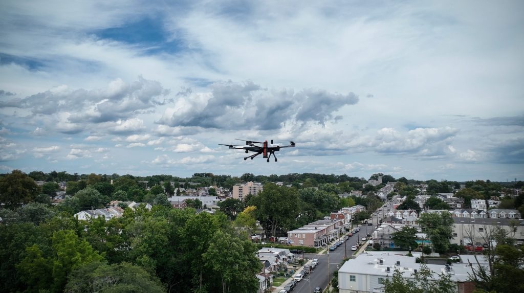 Guardian aerial surveillance drone from Asylon flies on a patrol over a tree-filled suburban neighborhood.