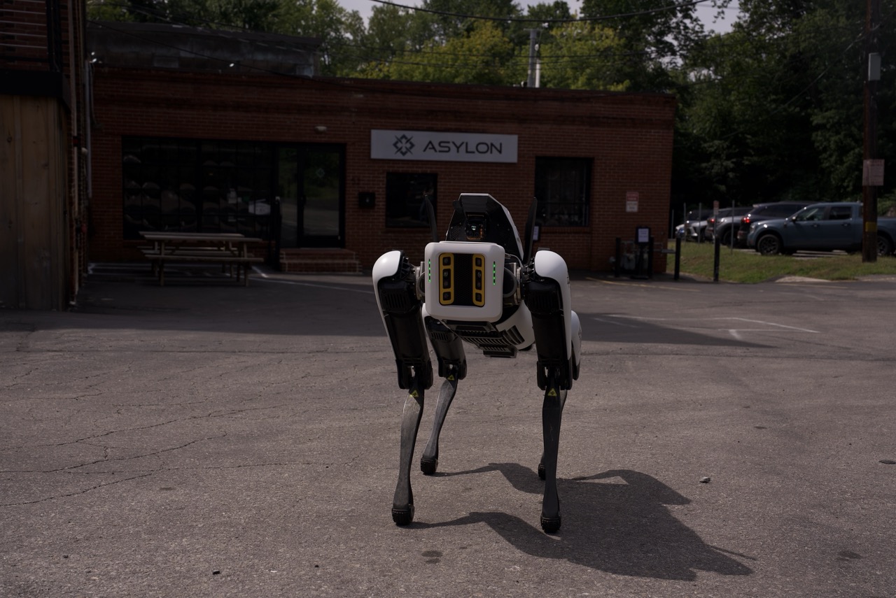 Quadruped Drone Dog security robot stands alert outside Asylon headquarters before its next patrol.