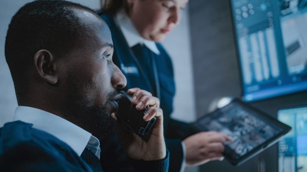 Security operators monitor camera feeds from a control room during an alarm verification process.