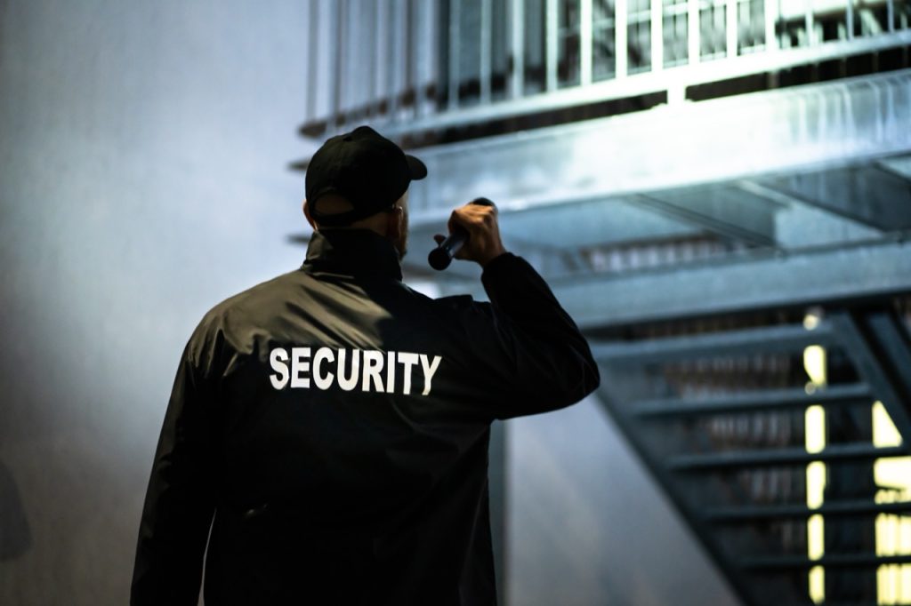 Security guard responding to a perimeter security concern during evening operations.