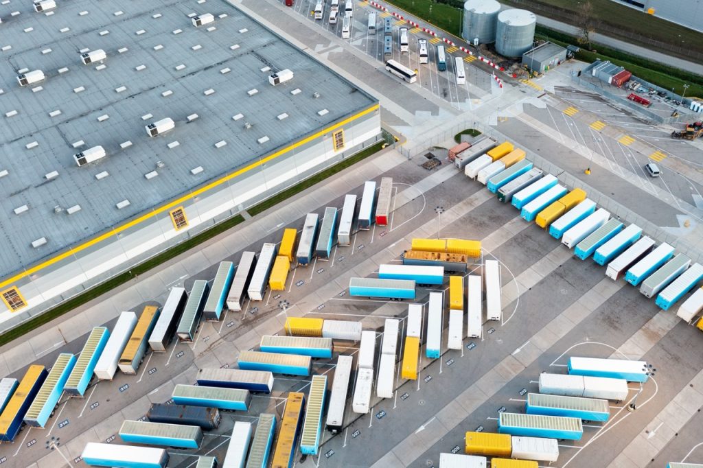 Aerial view of a distribution center with trailer staging areas and loading dock operations 	