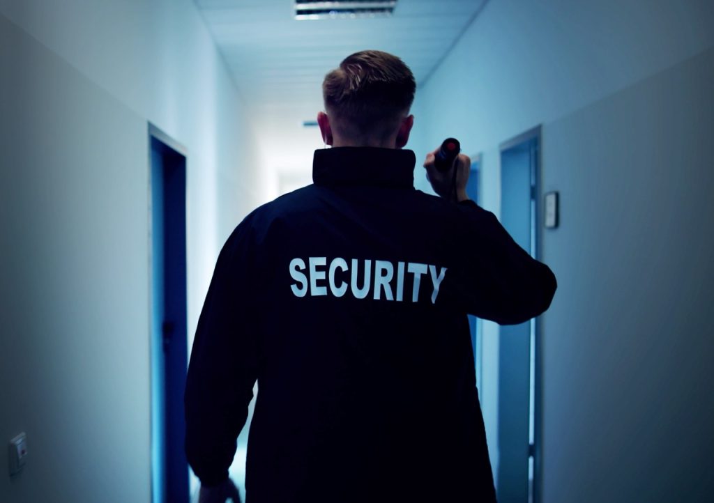Water treatment security guard patrols a hallway with a flashlight