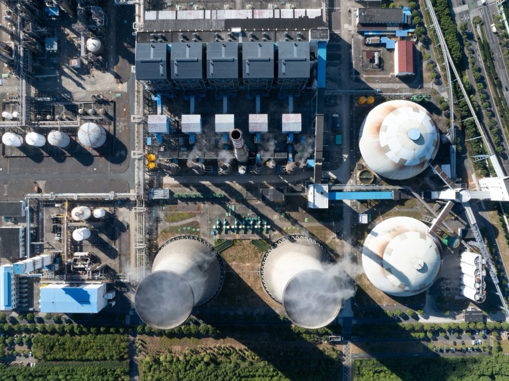 Aerial view of chemical plant featuring smokestacks, storage tanks, and process units.