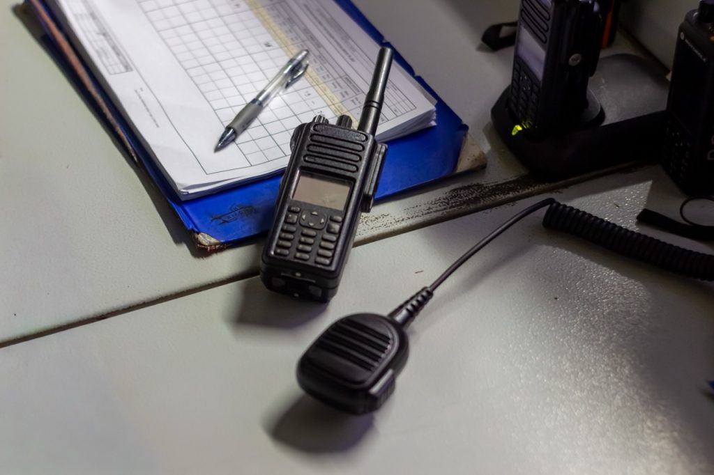 Two-way radios and patrol logs used to coordinate security operations and document patrol activity.