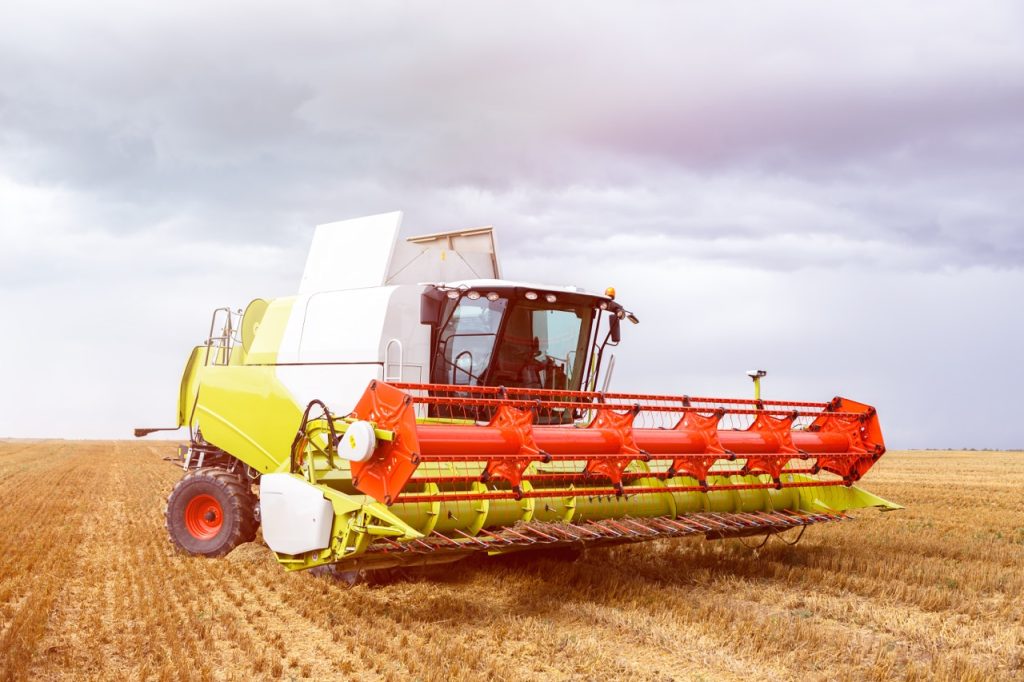 Combine harvester works a field, being tracked by on-board GPS device.