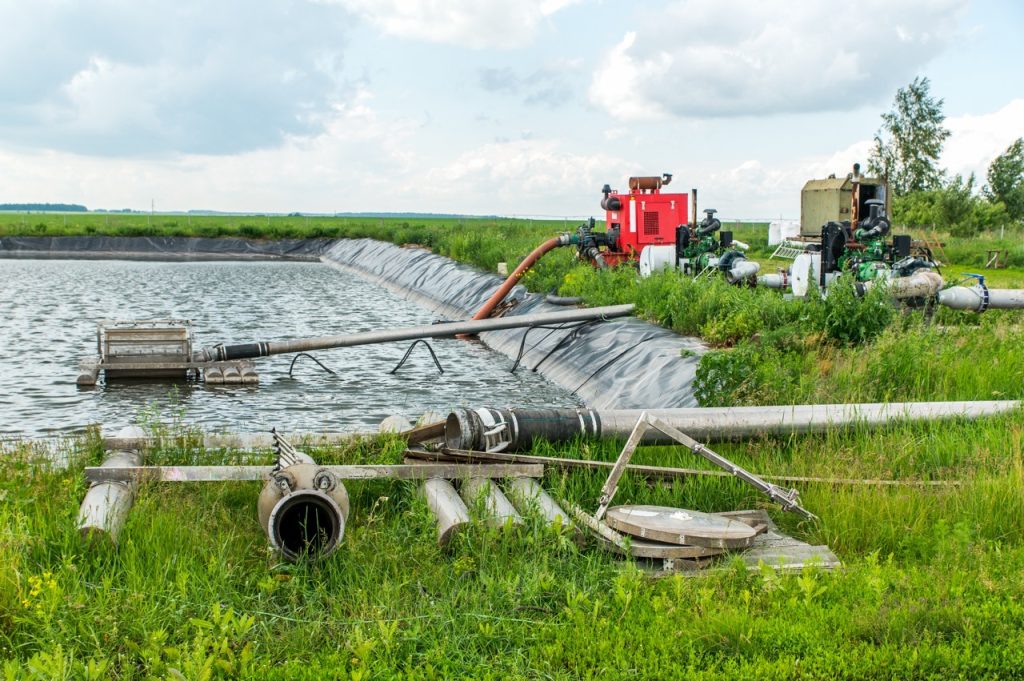 Water flows into a field at remote irrigation station on a commercial agricultural site.