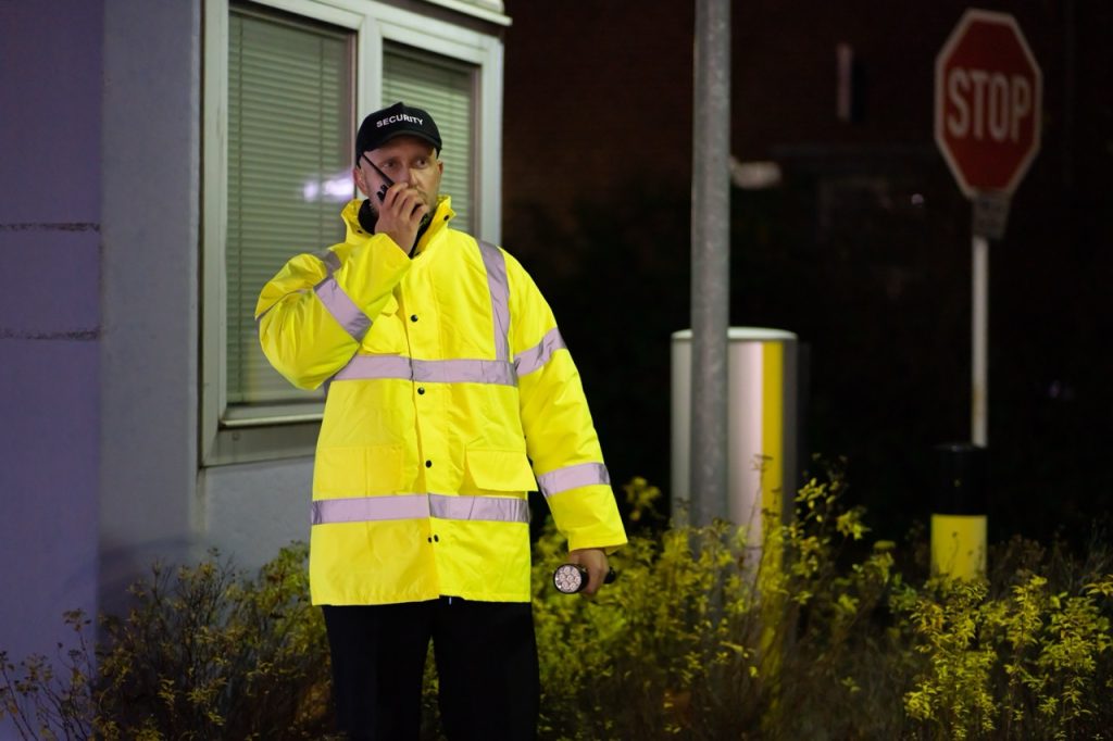 Airport security officer communicating by radio during an overnight perimeter patrol. 