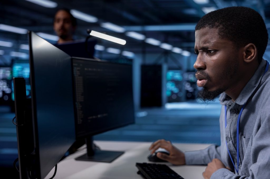 Data center security analyst monitoring systems from security operations workstation sees alert.