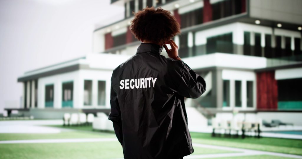 Private estate security officer monitoring a luxury residence during a perimeter patrol.  